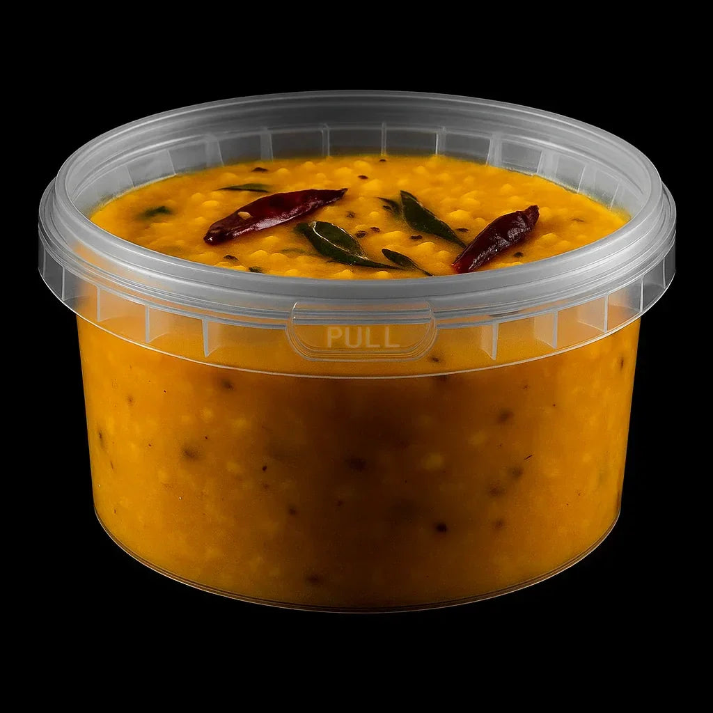 Disposable plastic food container filled with yellow lentil curry, isolated on black background.